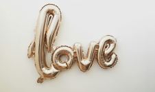 gold balloon spelling love on a white background